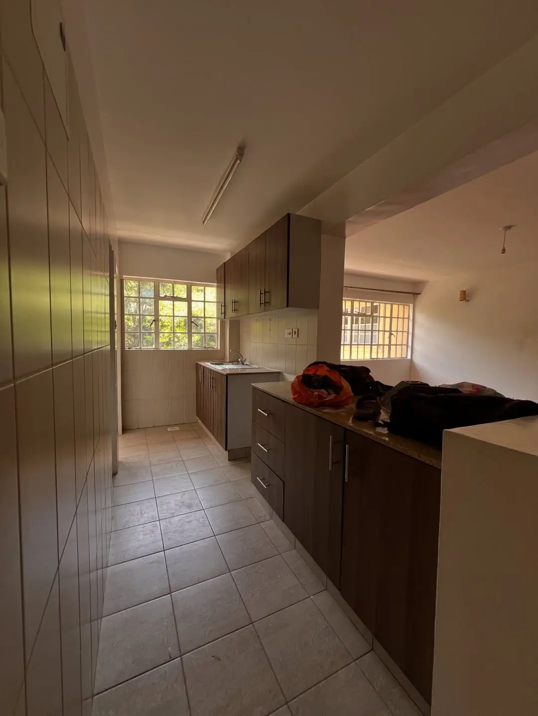 Galley kitchen with dark cabinetry and tiled flooring
