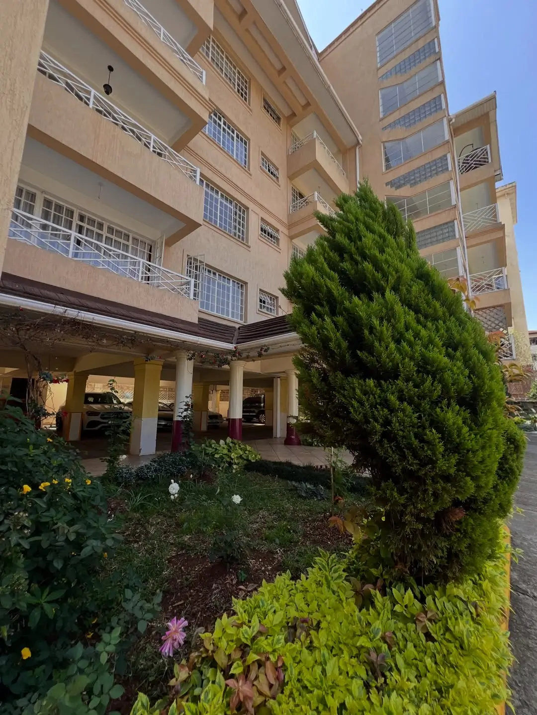 Multi-story residential building with manicured compound gardens