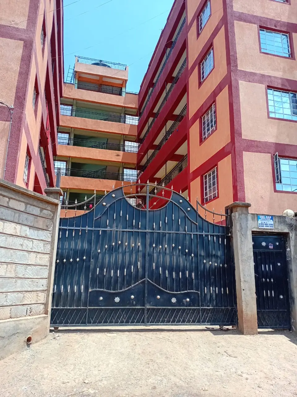 Residential building entrance with ornate metal gate and compound