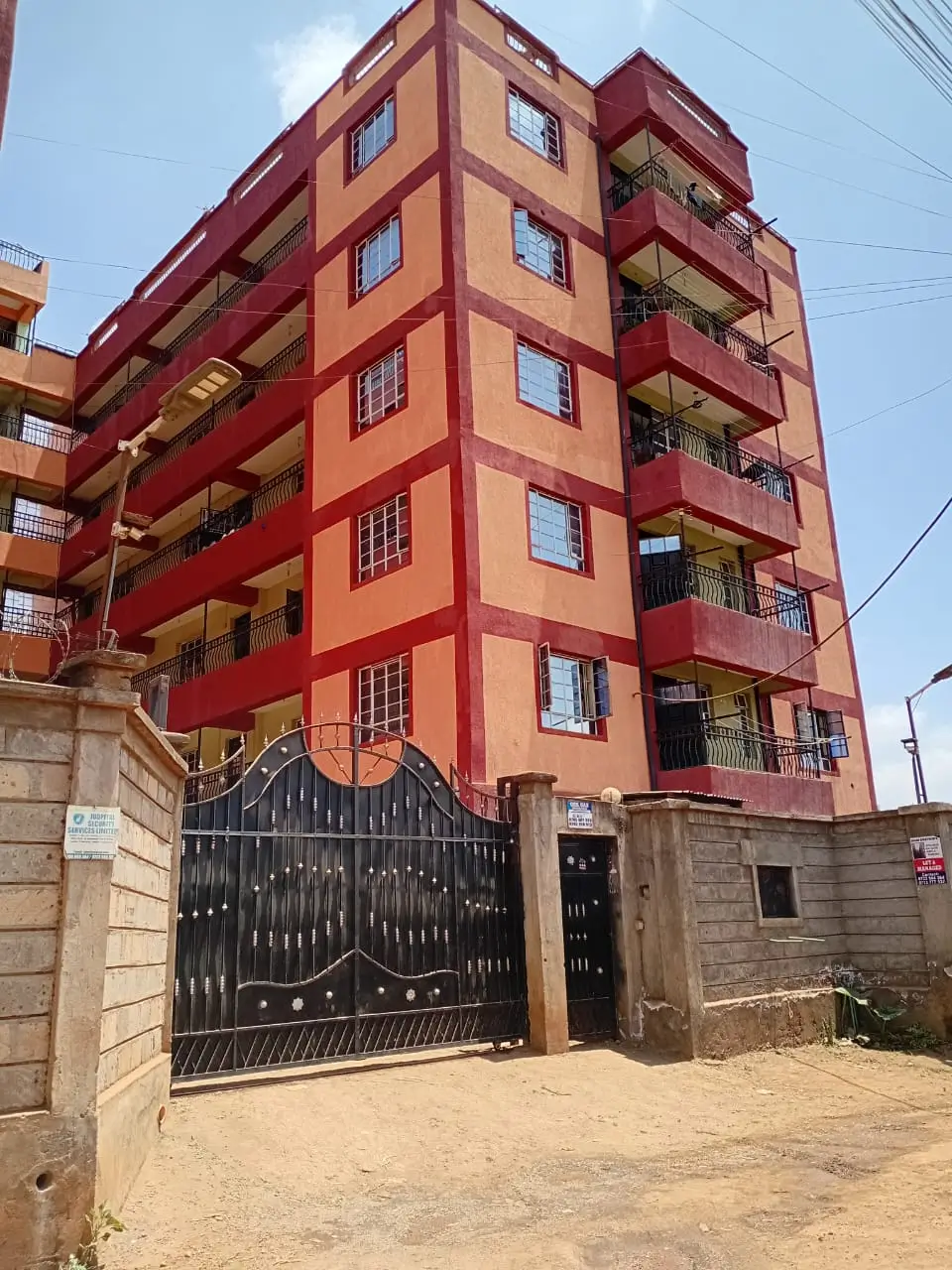 Multi-story residential building with red and orange facade