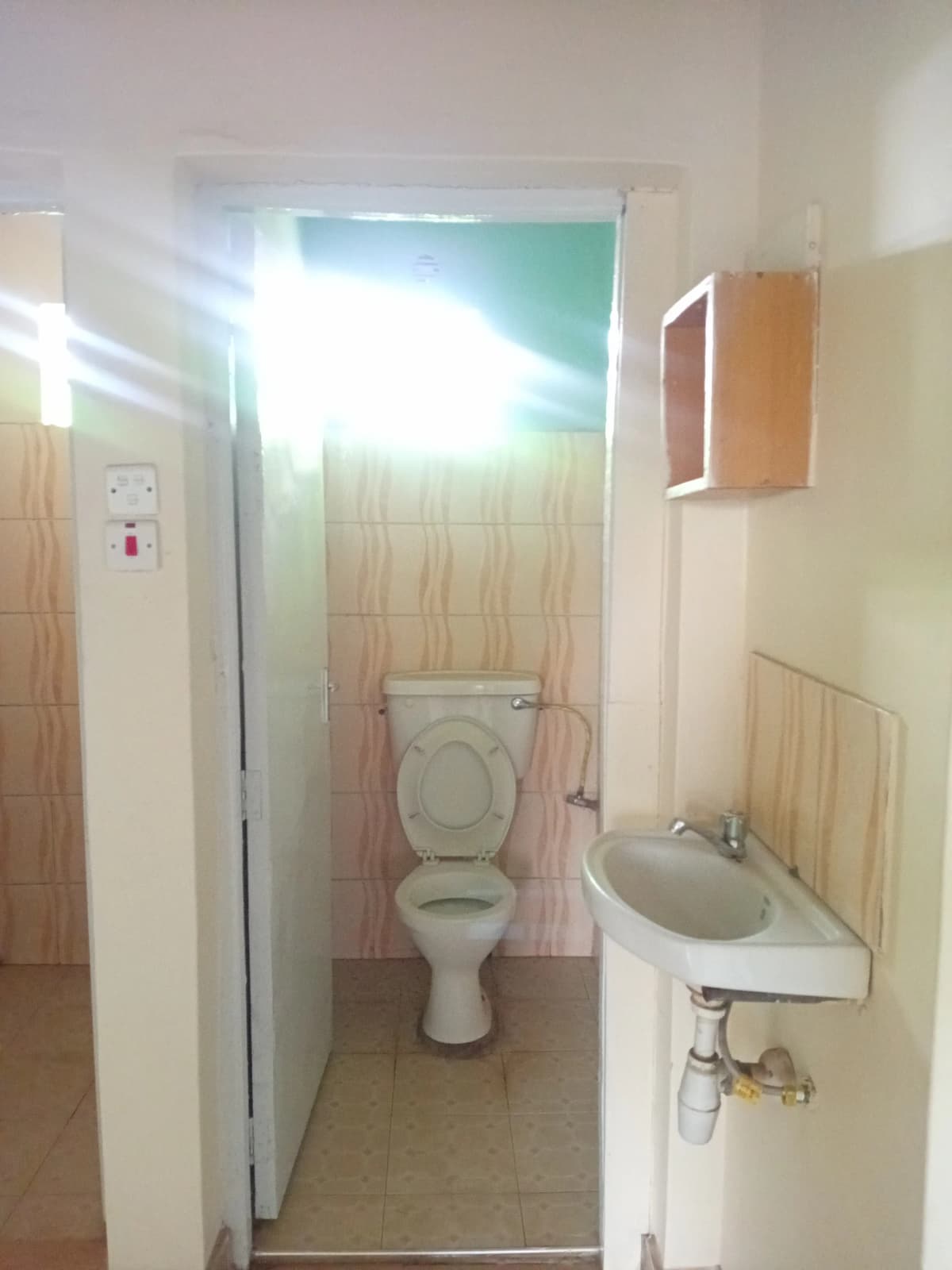Compact bathroom with toilet, sink, and shower cubicle
