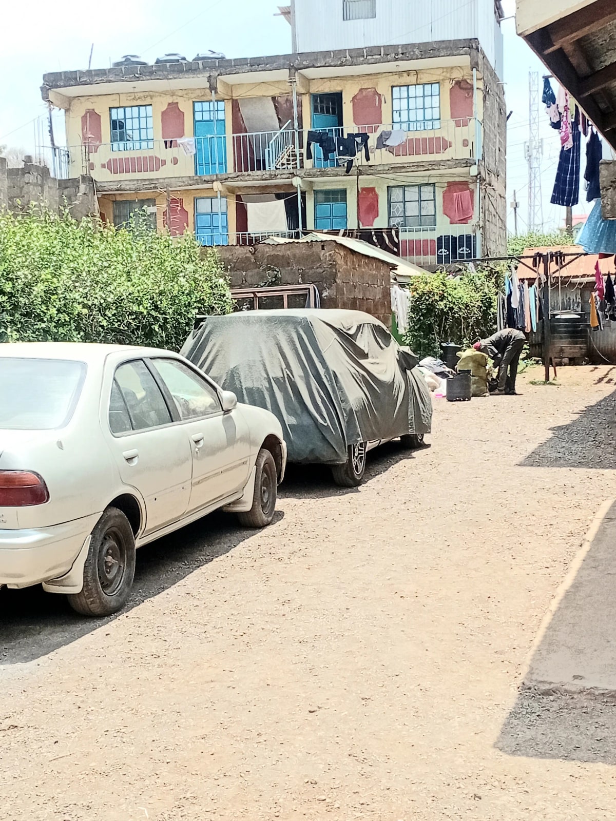 Compound parking area with vehicles and residential building