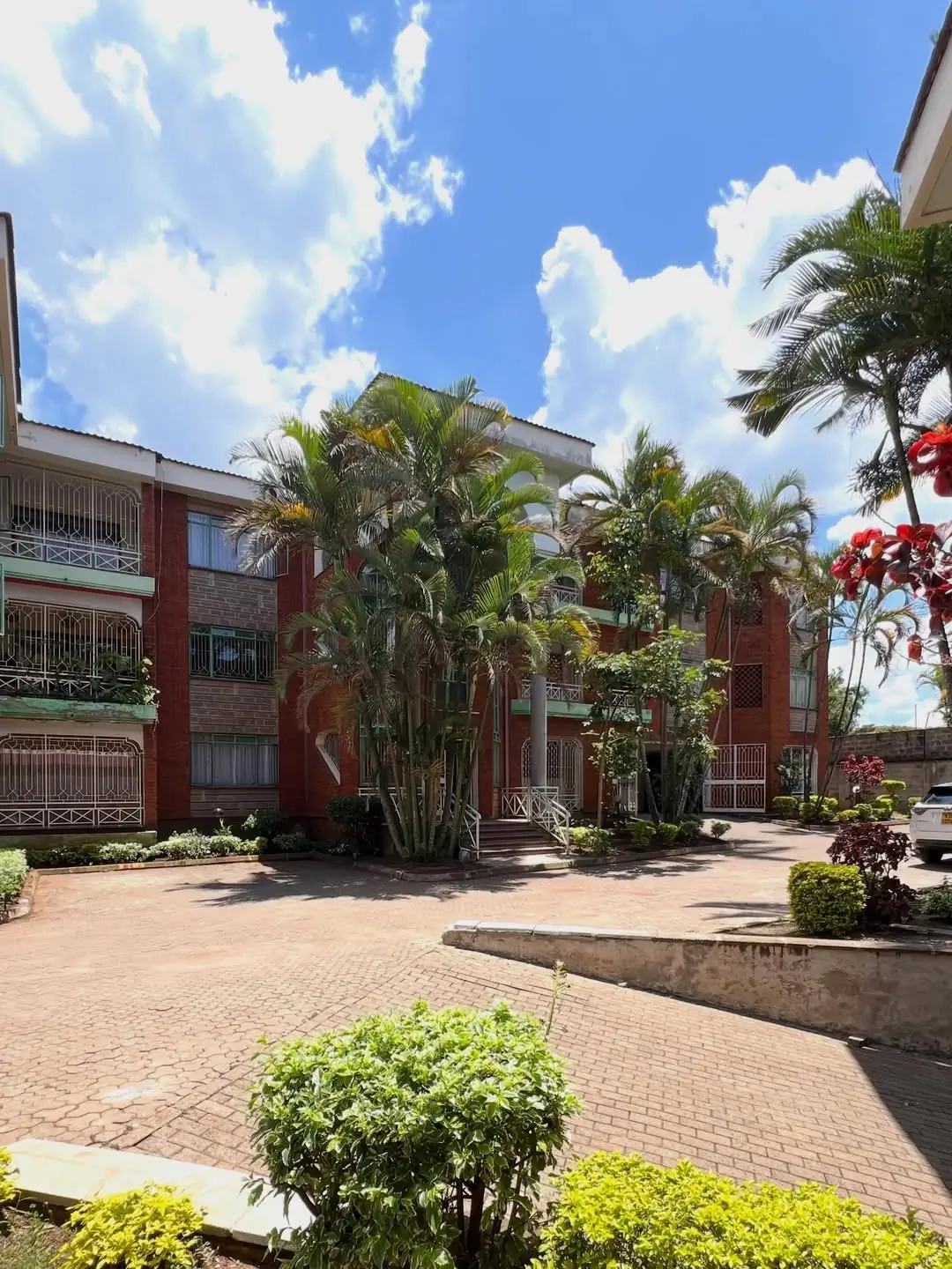 Multi-story residential building with manicured landscaping and courtyard