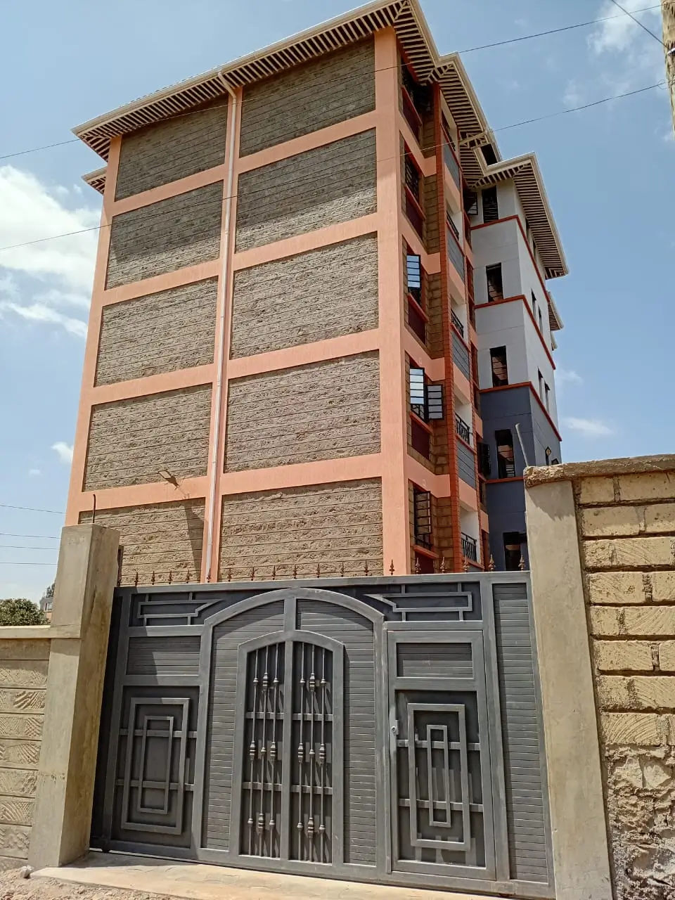 Multi-story residential building with metal gate entrance