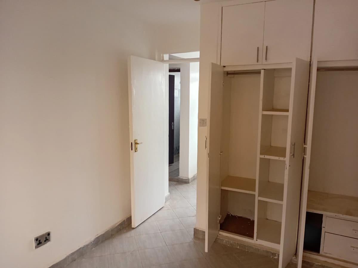 Unfurnished bedroom with built-in wardrobes and open doorway