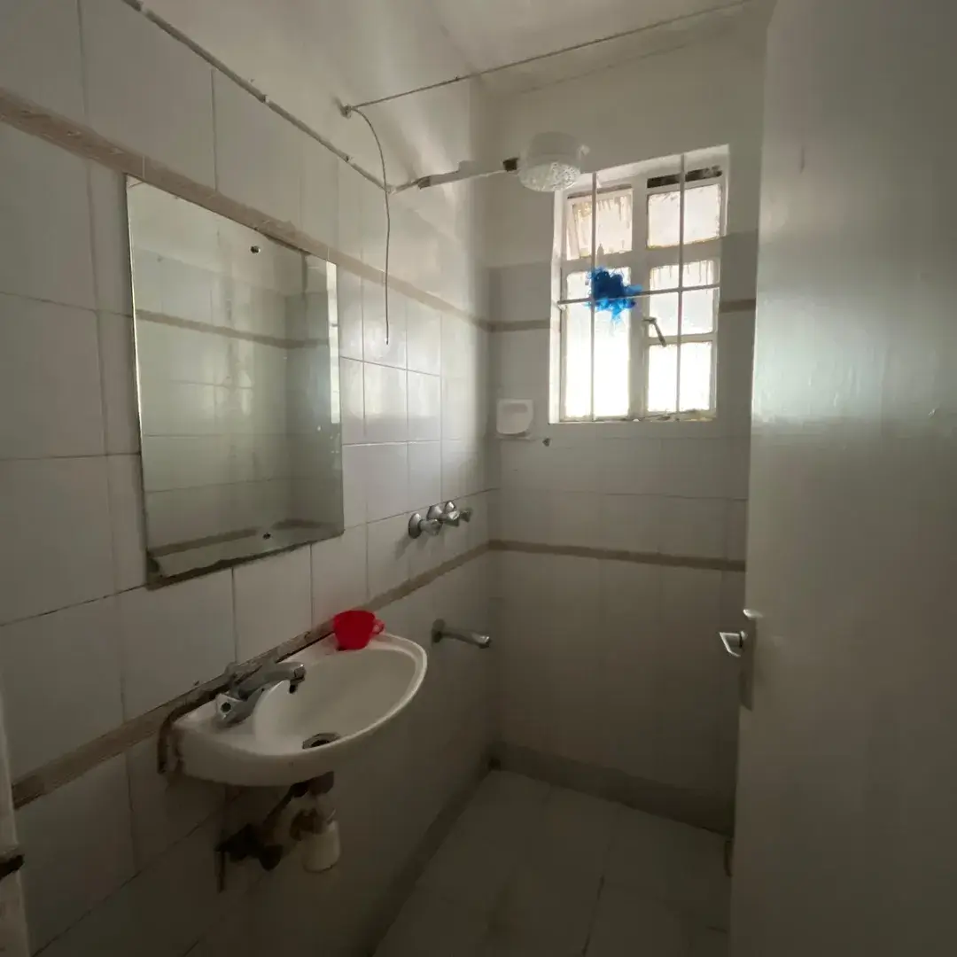 Bright bathroom with sink, mirror, and tiled walls