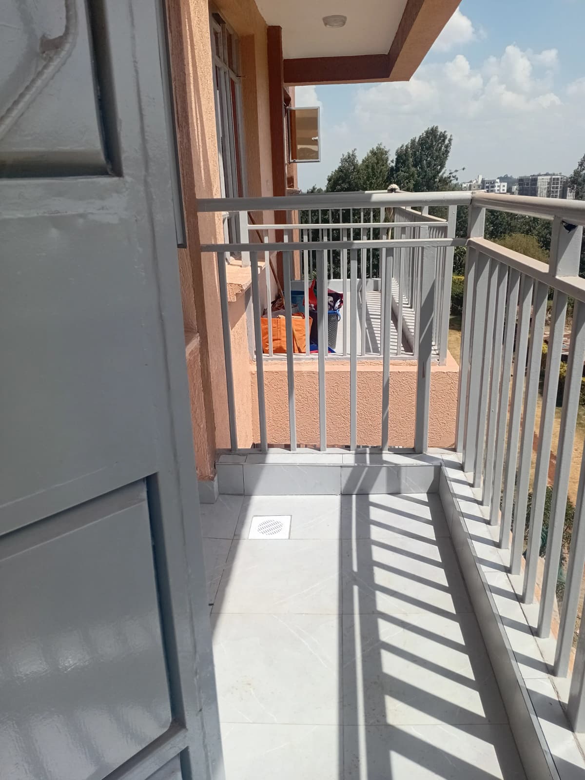 Spacious balcony with metal railing and city views