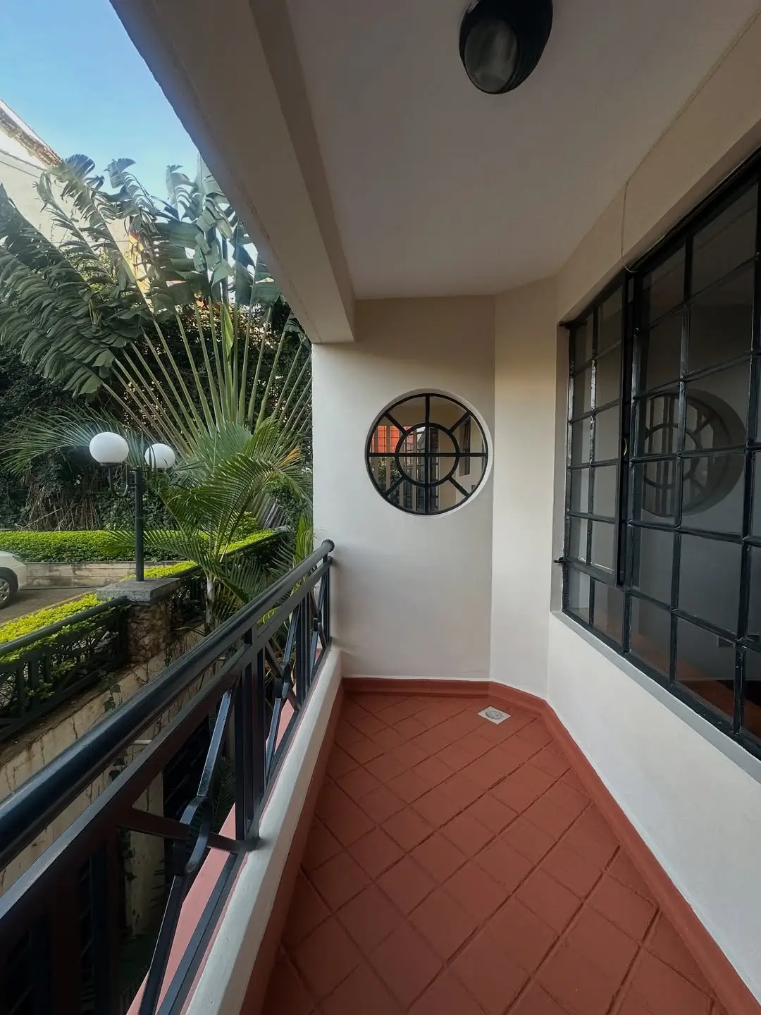 Covered terrace with red tile flooring and garden views