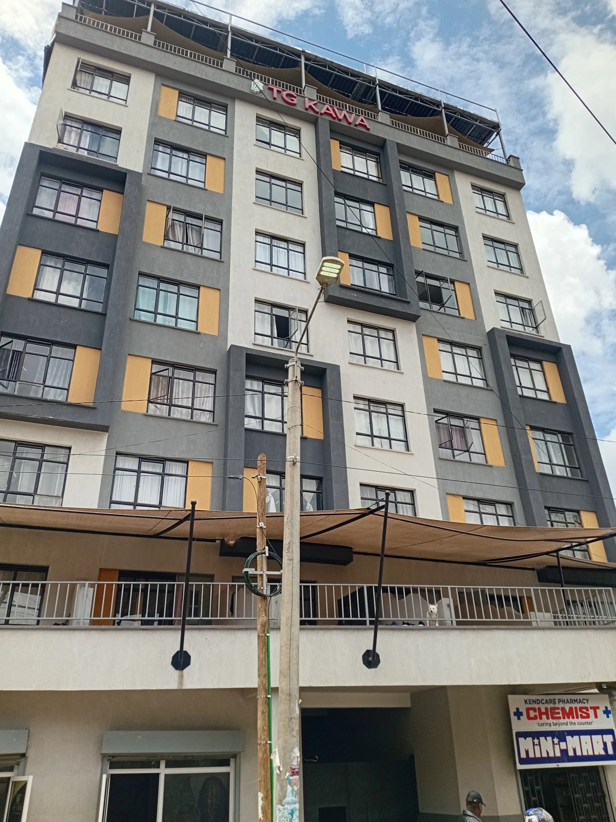 Multi-story residential building facade with yellow accent panels
