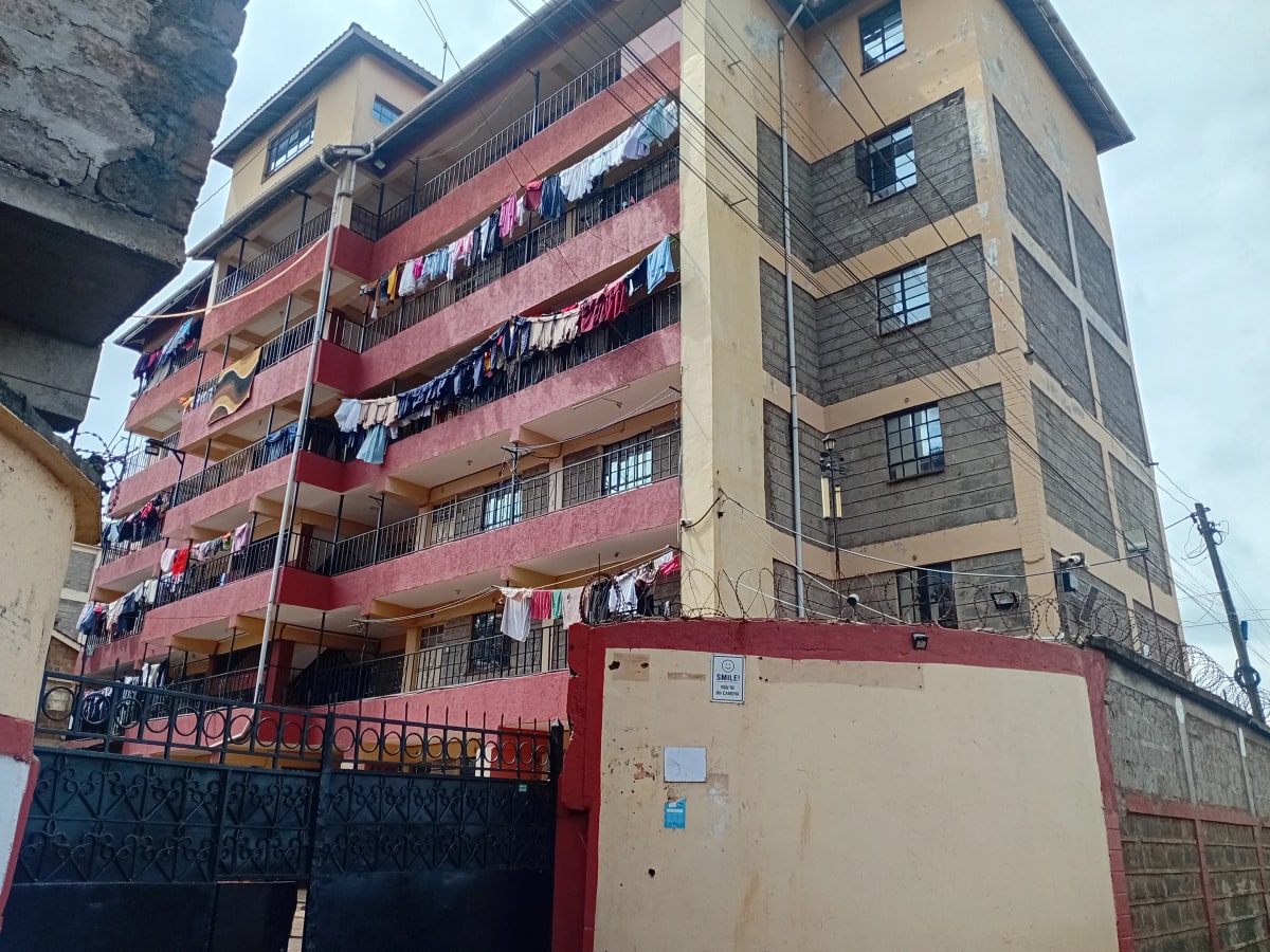 Multi-story residential building facade with red and cream paintwork