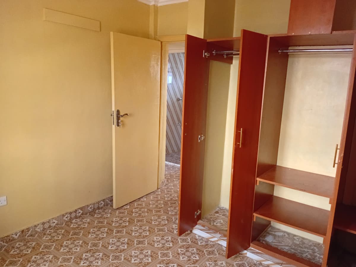Bedroom with built-in wardrobes and patterned tile flooring